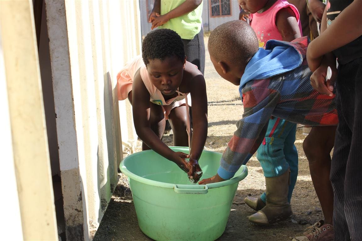Children washing their hands at Freedom Park before receiving their food (South Africa)